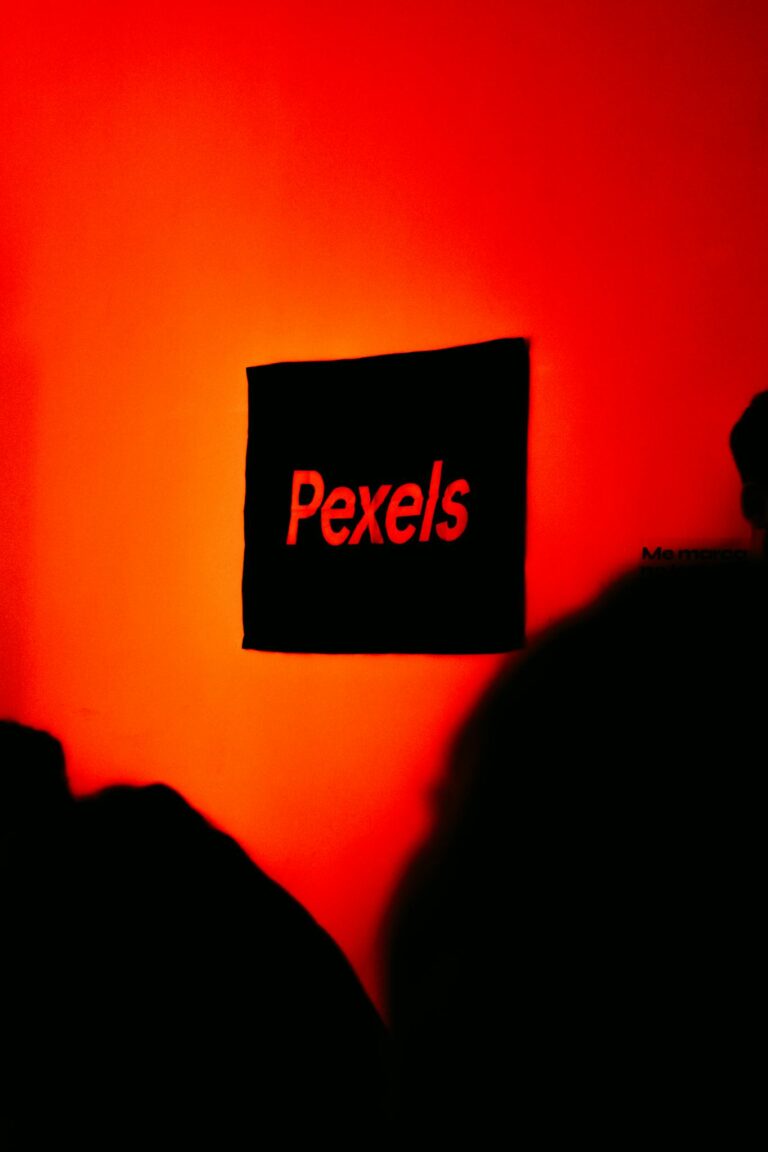 A striking red wall with the Pexels logo, creating a bold and modern aesthetic indoors.